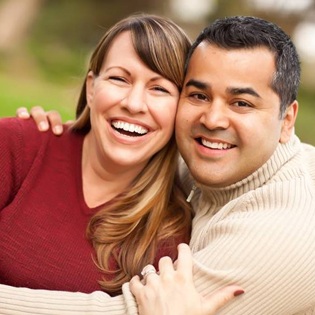 Couple smiling and embracing at the park