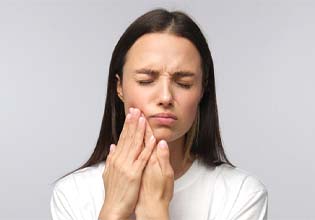 Woman with a toothache in Ware touching her face