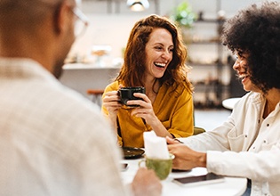 Friends smiling while enjoying coffee