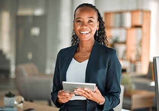 Smiling woman holding tablet in office
