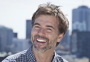 Man smiling with city skyline
