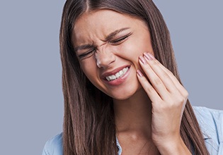 Woman in pain holding cheek