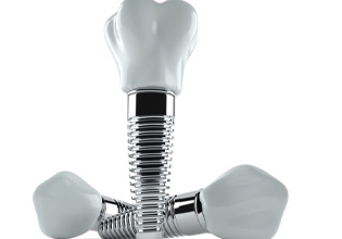 Three dental implants and crowns against white background