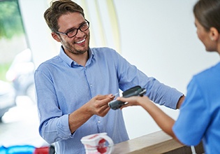 Patient paying for veneers in Ware