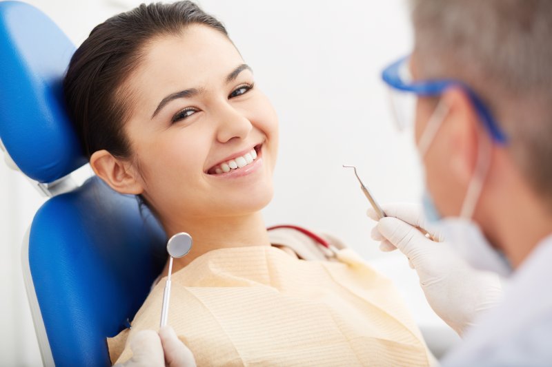 woman smiling during a dental checkup in Ware