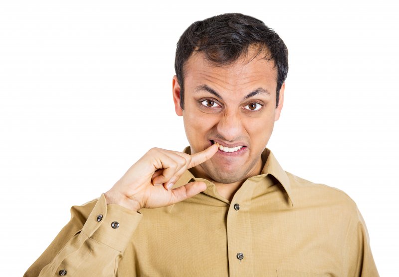 man picking food out of his teeth